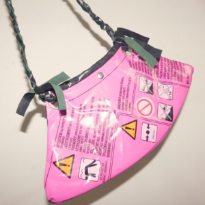 cartera diseñada a partir de inflables pinchados negro y magenta pvc recuperado con inscripciones y tira trenzada
