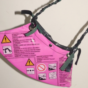 cartera diseñada a partir de inflables pinchados negro y magenta pvc recuperado con inscripciones y tira trenzada